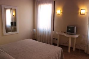 1 dormitorio con 1 cama y mesa con TV en Domus Orsoni, en Venecia