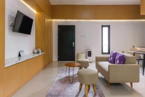 a living room with a couch and a chair at INNCA Amerta Villa, Solo in Solo