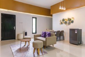 a living room with a couch and a table at INNCA Amerta Villa, Solo in Solo