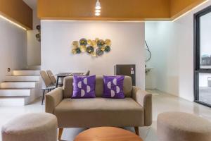 a living room with a couch and a clock on the wall at INNCA Amerta Villa, Solo in Solo +25 photos