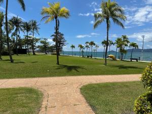 a path in a park with palm trees and the ocean at Shangri-La Tanjung Aru, Kota Kinabalu in Kota Kinabalu