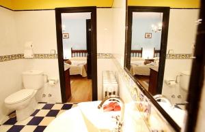 a bathroom with a toilet and a sink and mirrors at Hotel Casa de Indianos Don Tomás in Nueva de Llanes +28 photos