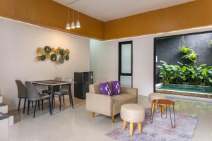 a living room with a table and chairs and a dining room at INNCA The Amerta Private Villa, Solo in Solo