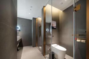 a bathroom with a toilet and a glass shower at Atour X Hotel Haikou Guoxing Avenue Sun Moon Plaza in Haikou +13 photos