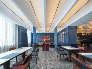 a restaurant with blue walls and tables and chairs at Atour X Hotel Haikou Guoxing Avenue Sun Moon Plaza in Haikou