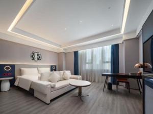 a living room with a white couch and a table at Atour X Hotel Haikou Guoxing Avenue Sun Moon Plaza in Haikou