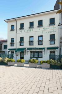 ein großes weißes Gebäude mit Pflanzen davor in der Unterkunft Ai Campi Di Marcello Hotel in Monfalcone