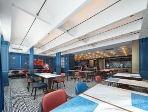 a restaurant with blue walls and tables and chairs at Atour X Hotel Haikou Guoxing Avenue Sun Moon Plaza in Haikou