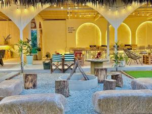 a patio with tables and chairs in a building at Beach House Pool Villa in Na Jomtien