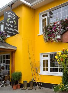 a yellow building with a sign on the side of it at Lydons Lodge Hotel in Cong