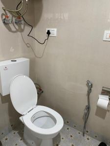 a bathroom with a white toilet and a shower at Al Jalal Resort in Srinagar +1 photo