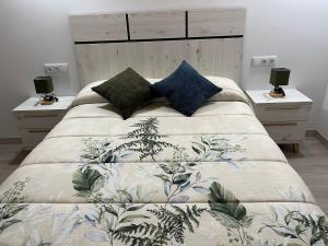a bedroom with a large bed with two night stands at Apartamentos Playa Frejulfe in Paderne