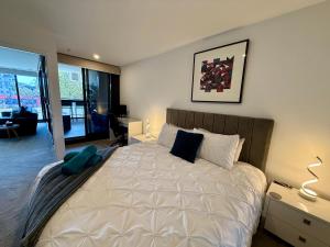 堪培拉Midnight Luxe 1BR 1Bath Apartment 104 in the heart of Braddon Pool Sauna Secure Parking Wine WiFi的房间里有一张大床的卧室 更多28张照片