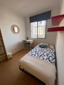ein kleines Schlafzimmer mit einem Bett und einem Fenster in der Unterkunft EstrellaMar in Arinaga