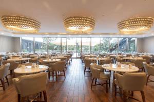 a restaurant with tables and chairs and large windows at Wyndham Grand Istanbul Kalamış Marina Hotel in Istanbul