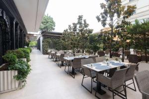 a restaurant with tables and chairs on a patio at Wyndham Grand Istanbul Kalamış Marina Hotel in Istanbul