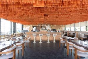 a restaurant with tables and chairs and a bar at Wyndham Grand Istanbul Kalamış Marina Hotel in Istanbul
