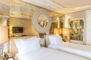 a hotel room with two beds and a mirror at Wyndham Grand Istanbul Kalamış Marina Hotel in Istanbul