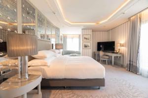a bedroom with a large bed and a desk at Wyndham Grand Istanbul Kalamış Marina Hotel in Istanbul