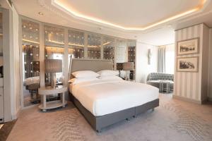 a bedroom with a large white bed and a desk at Wyndham Grand Istanbul Kalamış Marina Hotel in Istanbul