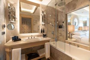 a bathroom with a sink and a shower and a tub at Wyndham Grand Istanbul Kalamış Marina Hotel in Istanbul