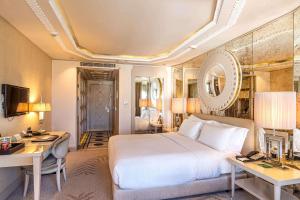 a hotel room with a bed and a desk and a desk at Wyndham Grand Istanbul Kalamış Marina Hotel in Istanbul