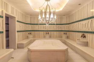 a large room with a chandelier and two sinks at Wyndham Grand Istanbul Kalamış Marina Hotel in Istanbul