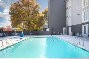 a swimming pool in a courtyard with a building at La Quinta by Wyndham Atlanta Airport South in Atlanta