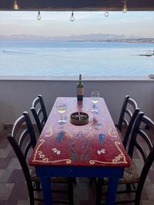 a table with a bottle of wine and wine glasses at Castello a Mare in Castellammare del Golfo +27 photos
