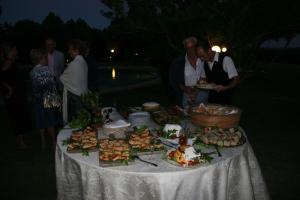 a group of people standing around a table with food at Hotel Spartivento in Chia