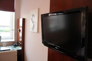 En tv och/eller ett underhållningssystem på Adena Hotel