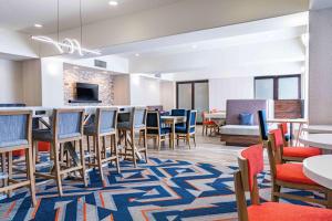 a room with chairs and tables and a bar at Hampton Inn Baton Rouge - Denham Springs in Denham Springs
