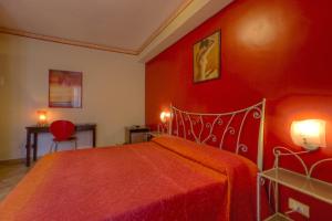 1 dormitorio rojo con 1 cama y pared roja en B&B Epos Acitrezza, en Aci Trezza