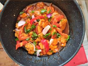 a wok filled with food with vegetables in it at turtles place- Chay's Bungalow in Esperanza