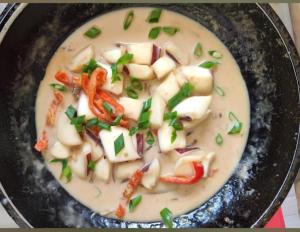 a bowl of soup with vegetables on top of it at turtles place- Chay's Bungalow in Esperanza