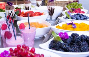 a table topped with bowls of fruit and drinks at Hotel Stadt München in Düsseldorf