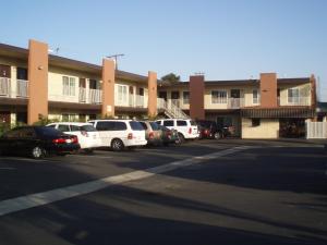 een parkeerplaats met auto's voor een gebouw bij Abby's Anaheimer Inn - Across Disneyland Park in Anaheim