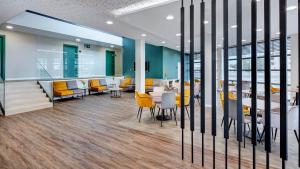 a conference room with yellow chairs and tables at Sercotel Córdoba Delicias in Córdoba