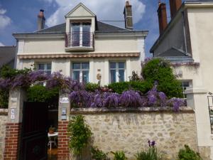 a house with purple flowers on a wall at Les Studios de Soizick in Amboise