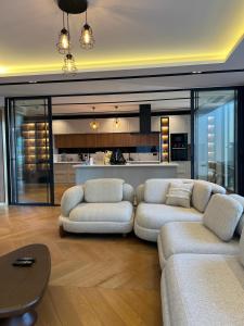 a living room with two couches and a kitchen at Royal Garden 7 Villas in Dosemealti