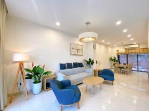 a living room with a couch and a table and chairs at New Life Bai Chay Condotel in Ha Long +57 photos
