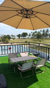 a table and two chairs under a large umbrella at VILLA CHENTA BACHOk KELANTAN in Bachok