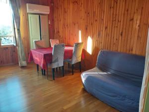 una sala da pranzo con tavolo, sedie e divano di Vanessa et Julien 1 a Vailly-sur-Sauldre
