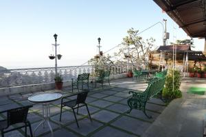 a patio with tables and chairs and the ocean at Sansa By The Woods - Manor&Spa in Mussoorie