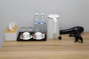 a tray with cups and water bottles on a desk at GO INN BTS Nana Sukhumvit Soi 3 x โกอินน์ บีทีเอส นานา ซอย 3 in Makkasan
