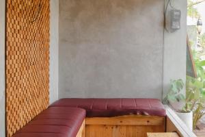 a red leather bench sitting in a room at Exotic Inn Semarang, by INNCA COLLECTION in Semarang