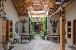 a hallway with tables and paintings of giraffes on the wall at Exotic Inn Semarang, by INNCA COLLECTION in Semarang