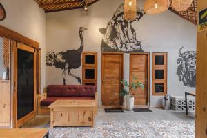 a living room with a dinosaur mural on the wall at Exotic Inn Semarang, by INNCA COLLECTION in Semarang