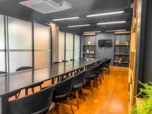 a conference room with a long table and chairs at 12 The Residence Hotel at Don Mueang Airport in Bangkok