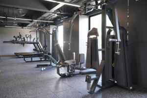 a gym with several tread machines in a room at 12 The Residence Hotel at Don Mueang Airport in Bangkok